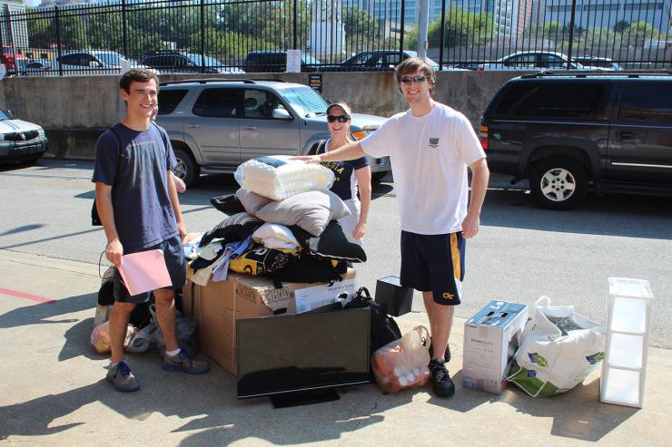 Students with materials they are moving out of their dorm