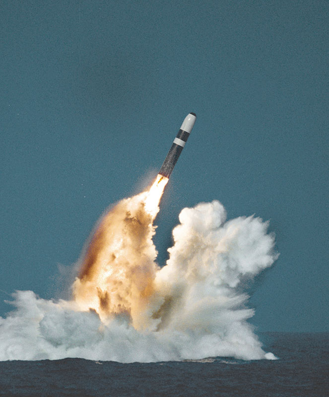Trident missile launched from a submarine with exhaust and flames over the water